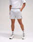 Person wearing light gray shorts with a brand logo on a white background