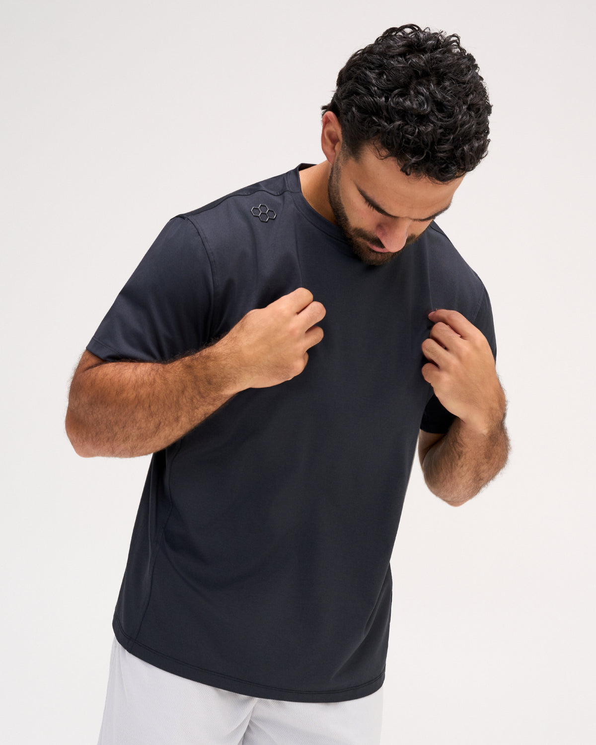 Model wearing the RUDIS Performance Heather T-Shirt in Heather Black, featuring a dark charcoal finish, short sleeves, crew neckline, and subtle RUDIS shoulder emblem.