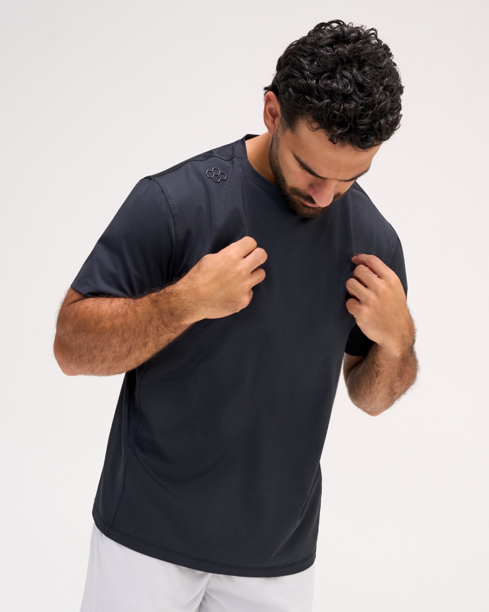 Model wearing the RUDIS Performance Heather T-Shirt in Heather Black, featuring a dark charcoal finish, short sleeves, crew neckline, and subtle RUDIS shoulder emblem.