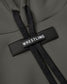 Close-up of a green hoodie with a black 'WRESTLING' tag and textured black drawstrings, showcasing a stylish and functional design.
