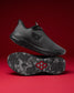 Black athletic shoe with a red logo on a red background