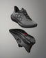 Gray athletic shoe with black sole on a gray background