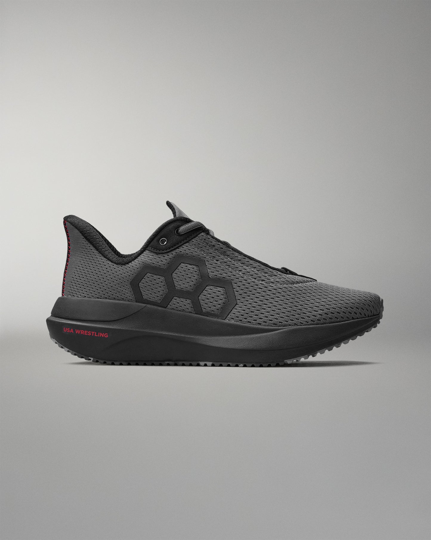 Gray athletic shoe with black accents on a gray background