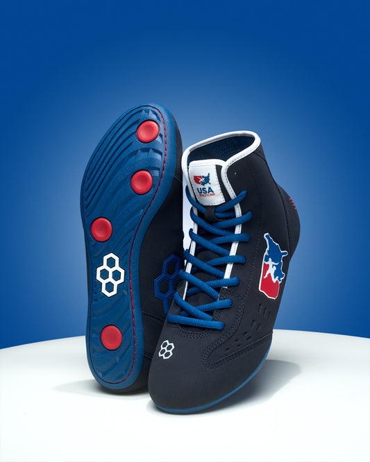 Pair of blue and black wrestling shoes with red accents on a blue background