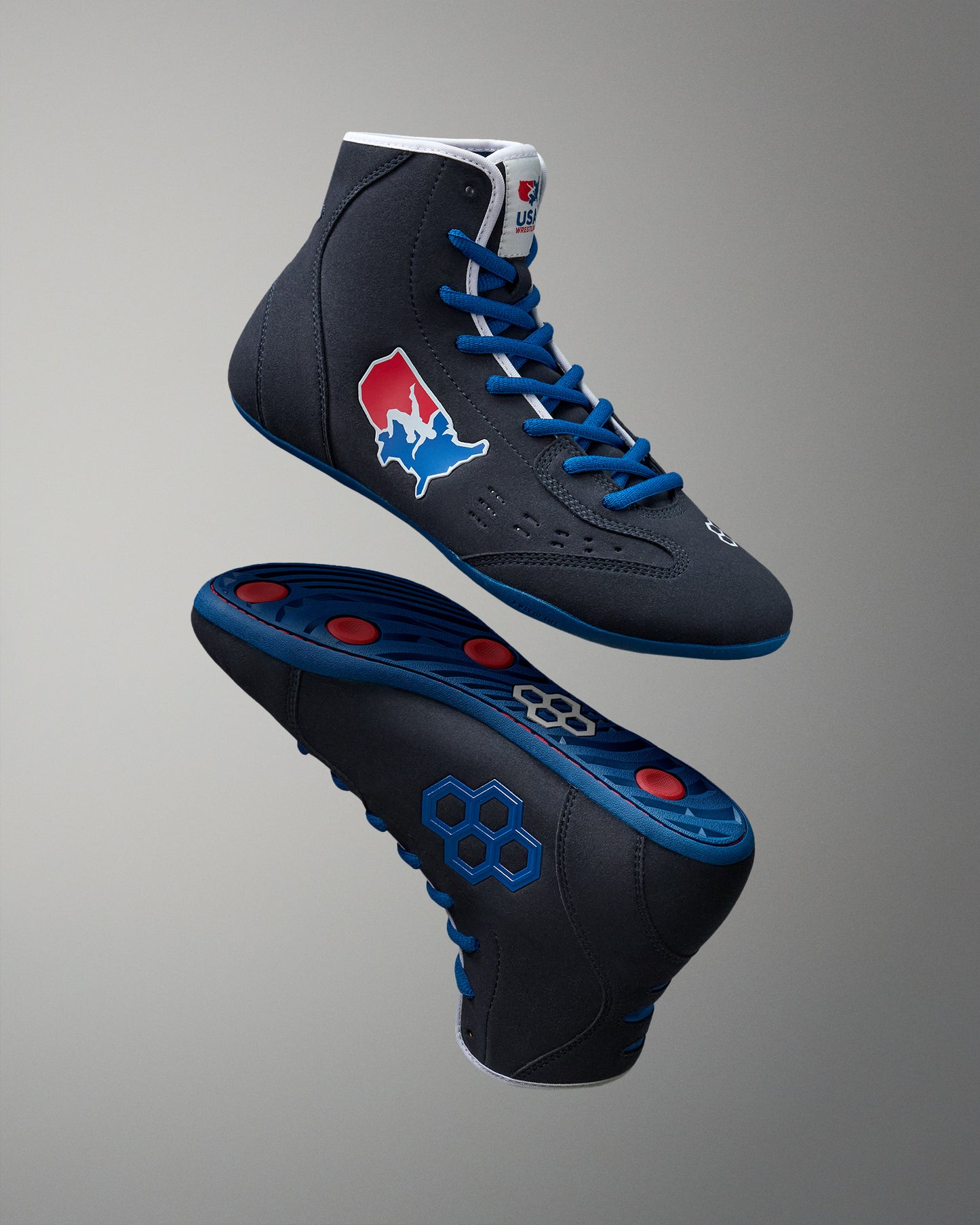 Black wrestling shoes with blue laces and red accents on a gray background