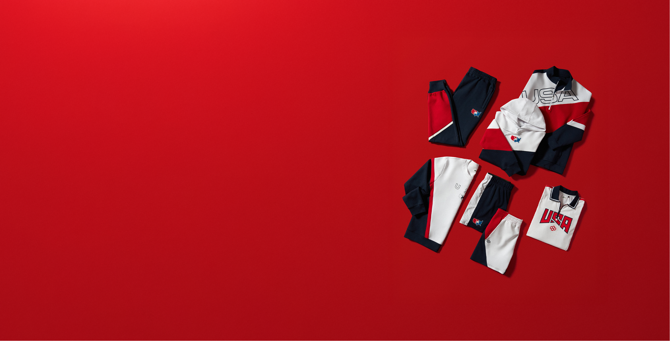 Collection of  USA Wrestling clothing items including shirts and pants on a red background
