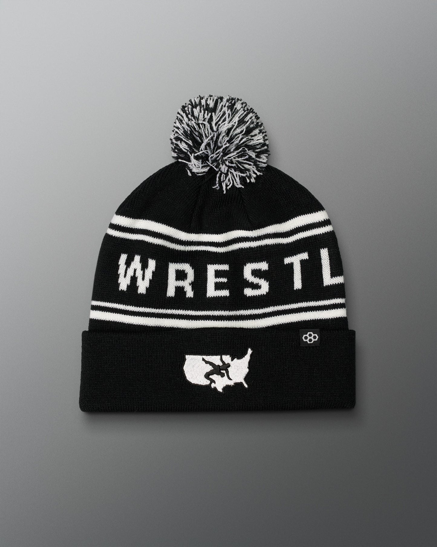 Black USA Wrestling Logo beanie with white text and pom-pom on a gradient background