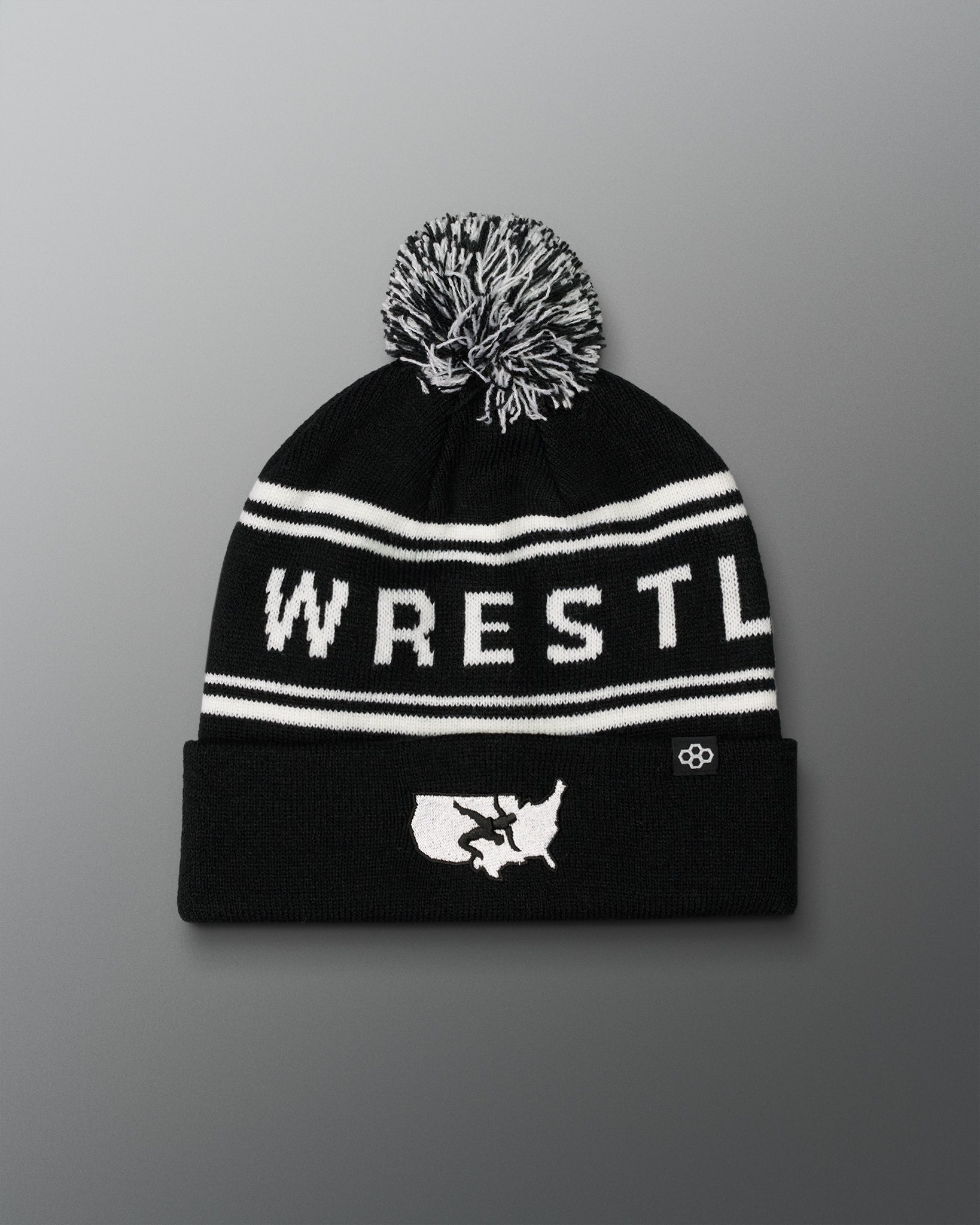 Black USA Wrestling Logo beanie with white text and pom-pom on a gradient background
