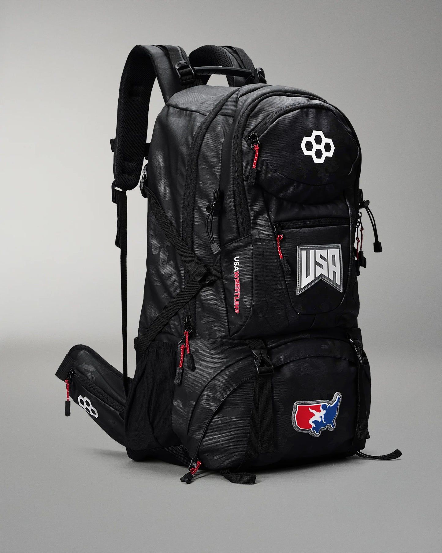 Black backpack with USA and logo patches on a gray background