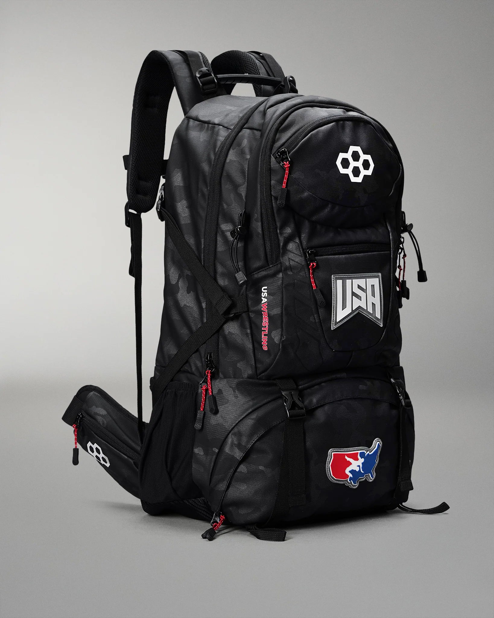 Black backpack with USA and logo patches on a gray background