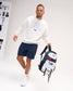 Full-body view of a model carrying the RUDIS USA Wrestling Genesis Gearpack III backpack by its top handle, showcasing patriotic red, white, and blue styling, USA Wrestling logos, and multiple storage compartments.
