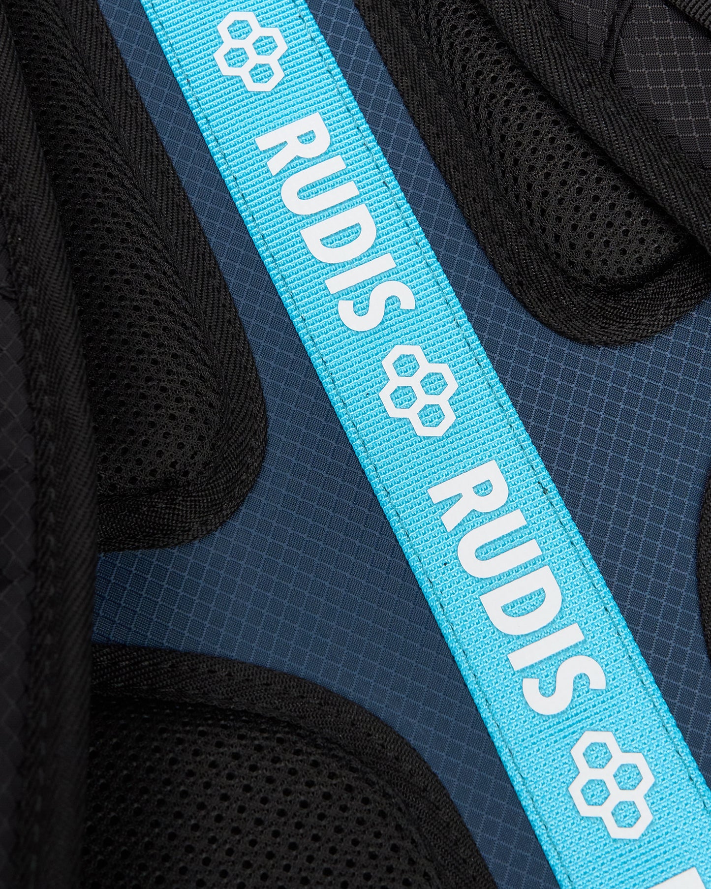 Close-up of a bright blue webbed strap with white 'RUDIS' text and paw-print logos, laid diagonally over black mesh athletic padding.