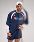 Man wearing a USA Wrestling tracksuit and cap on a plain background