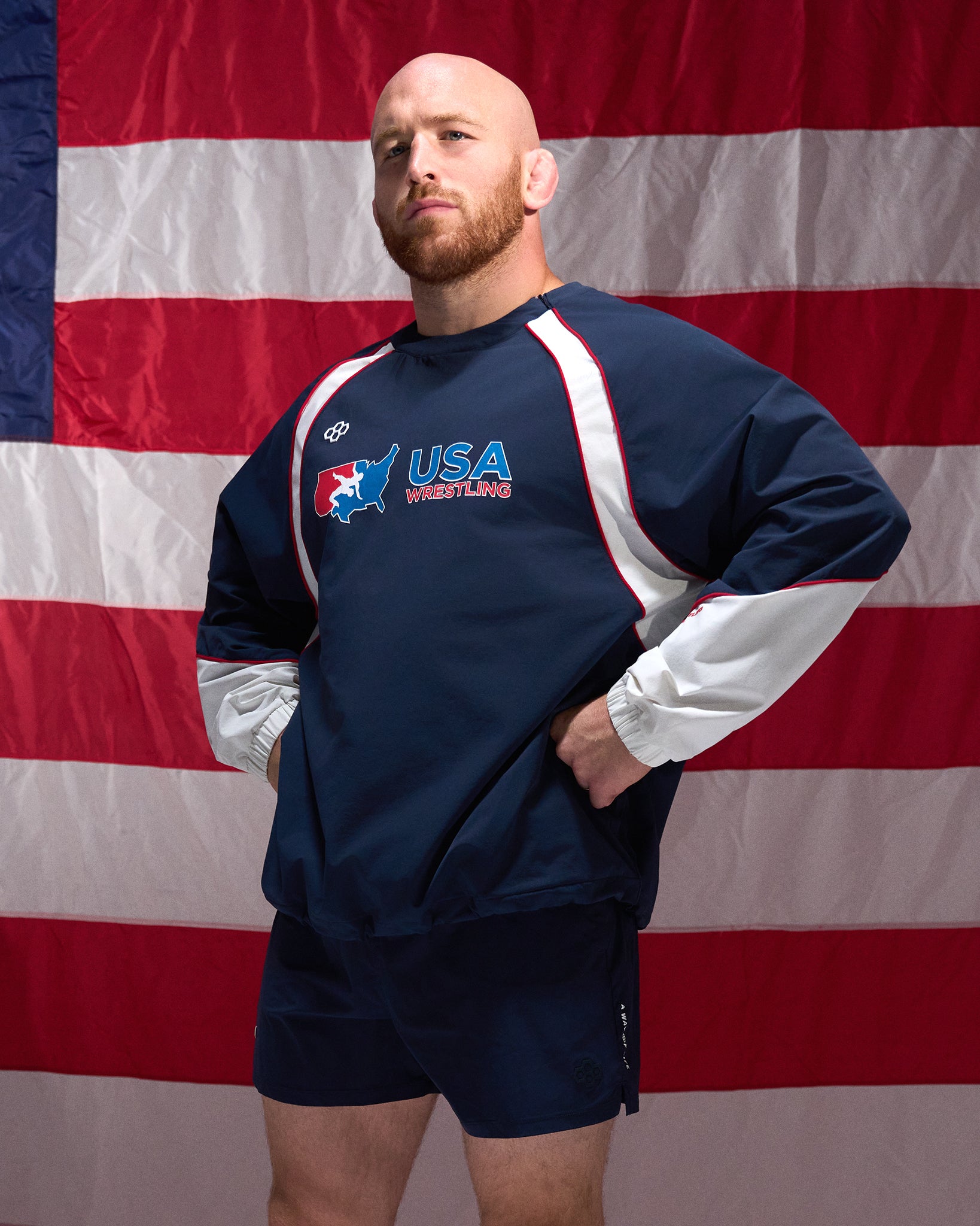 Man wearing a USA Wrestling sweatshirt in front of an American flag