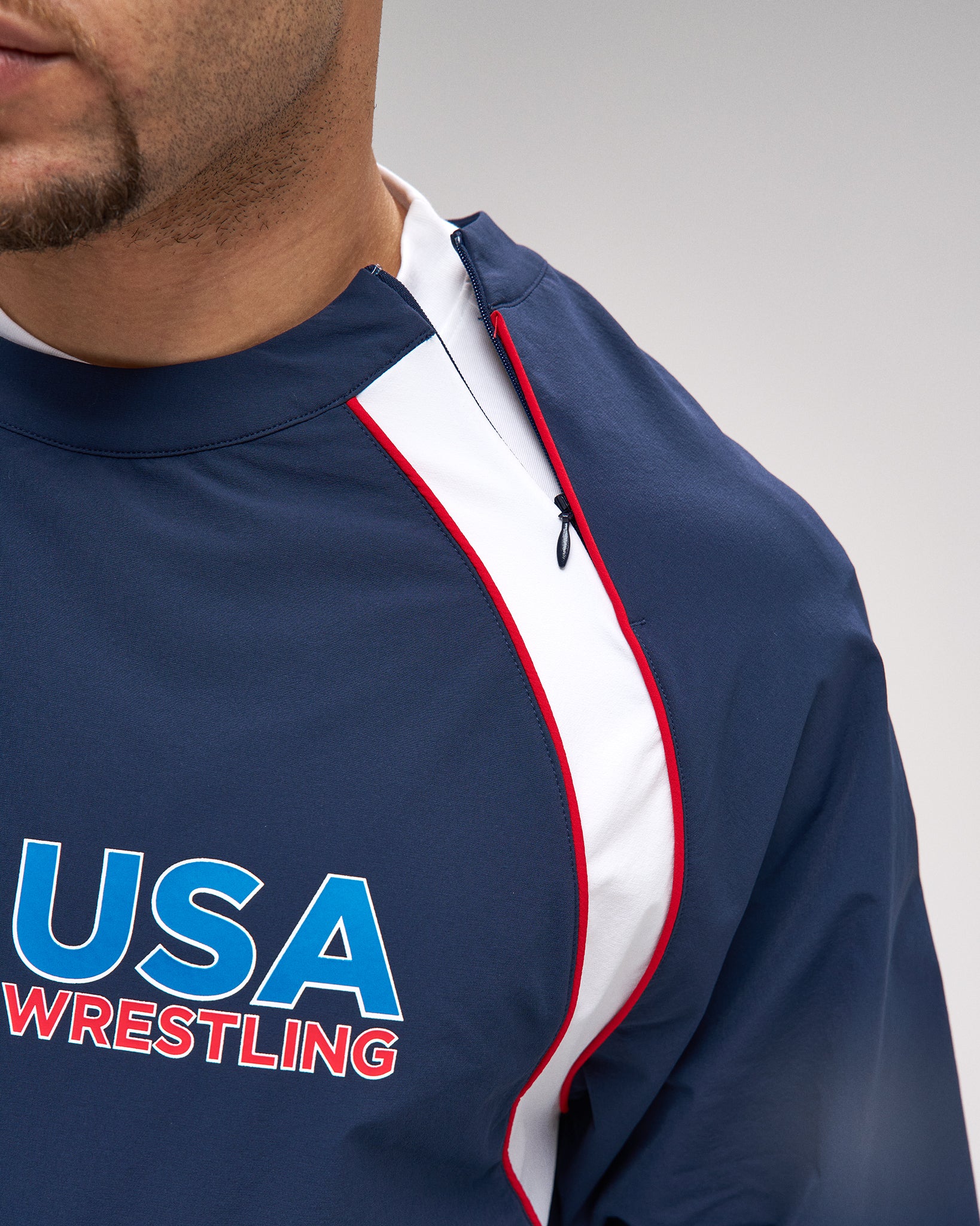 Navy blue sports jacket with 'USA Wrestling' logo on a gray background