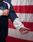 Person wearing a USA Wrestling jacket with an American flag in the background