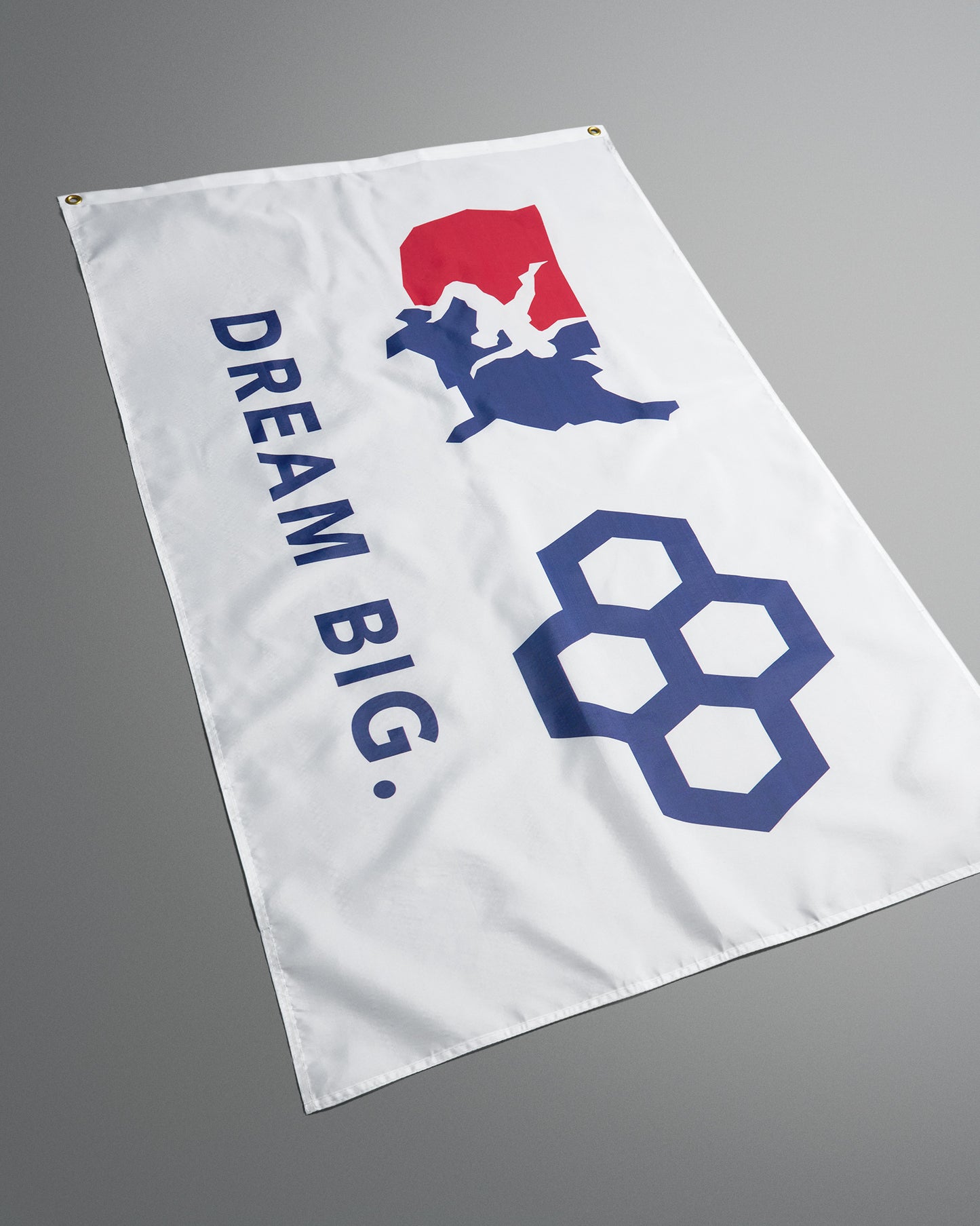 White flag with 'Dream Big' text and logo on a gray background