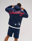 Back view of the RUDIS USA Wrestling Script Relaxed Comfort Fleece Hoodie in Navy, featuring oversized red Wrestling script across the shoulders and distressed white stars near the hem.
