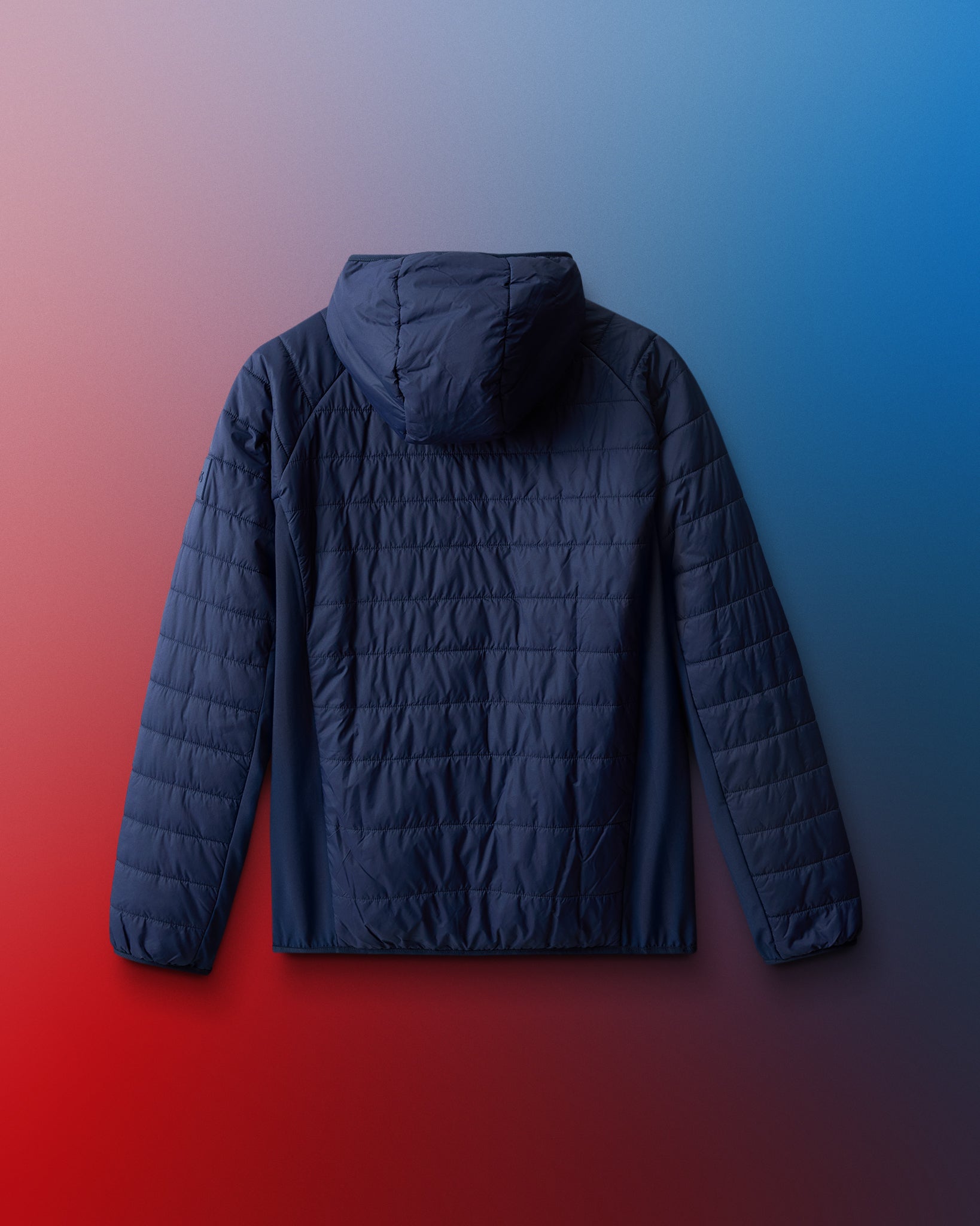 Dark blue quilted jacket on a gradient red to blue background