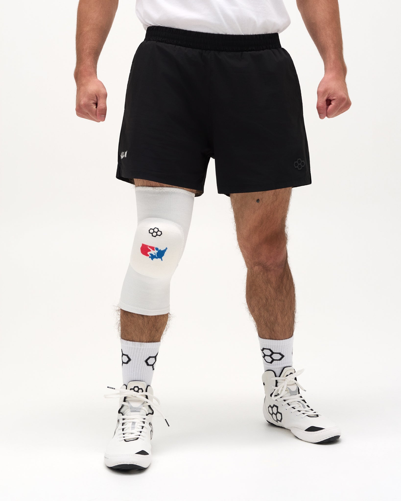 Front view of RUDIS USA Wrestling Map Cushion Knee Pad in white worn with wrestling shoes.