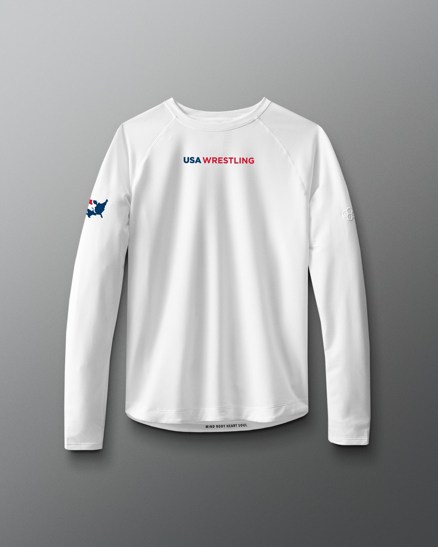 A long sleeve white t-shirt with 'USA WRESTLING' text and a small graphic on the chest area, displayed against a red to blue gradient background.