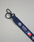 Close-up of the navy USA Wrestling lanyard featuring a durable black metal key clip, key ring, woven polyester strap, USA Wrestling logo, and RUDIS honeycomb branding.