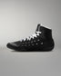 Black wrestling shoe with white laces on a gray background
