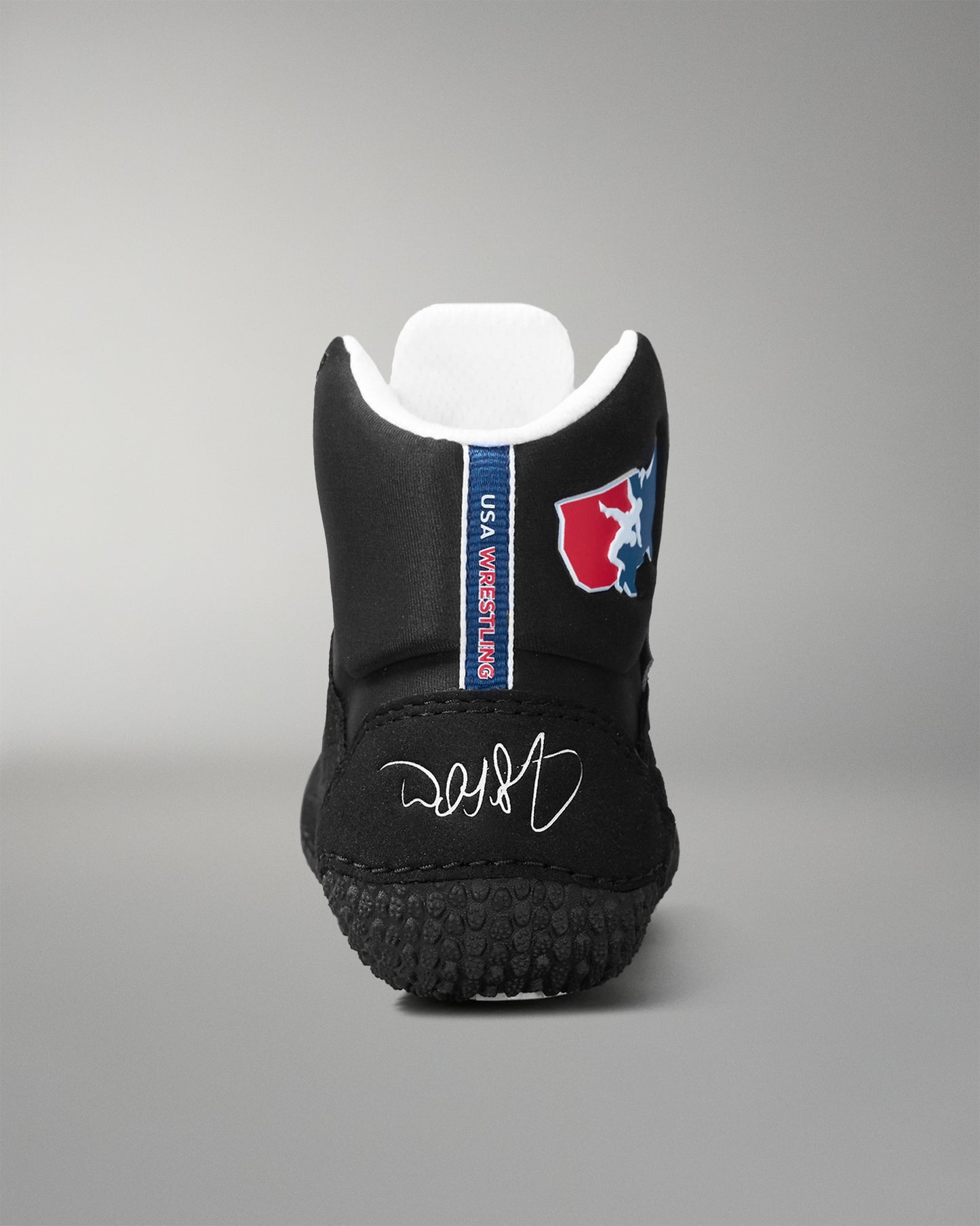 Black wrestling shoe with a logo and text on a gray background