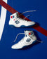 White wrestling shoes with blue soles and red, white, and blue accents on a blue background. USA Wrestling