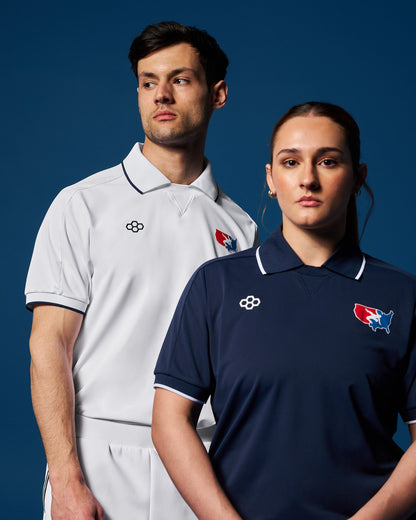 A male and a female wrestler standing side by side wearing USA Wrestling polos in white and blue colors, with the male in the foreground and the female in the background.