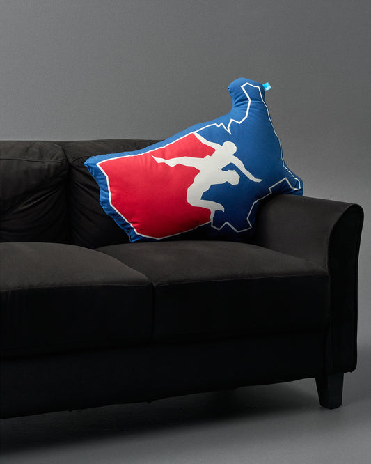 Decorative pillow with a logo on a black couch against a gray background