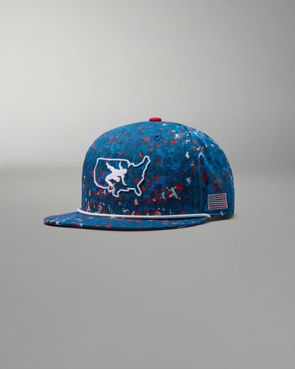Blue cap with red, white, and blue speckles and a USA wrestling map design on a gray background