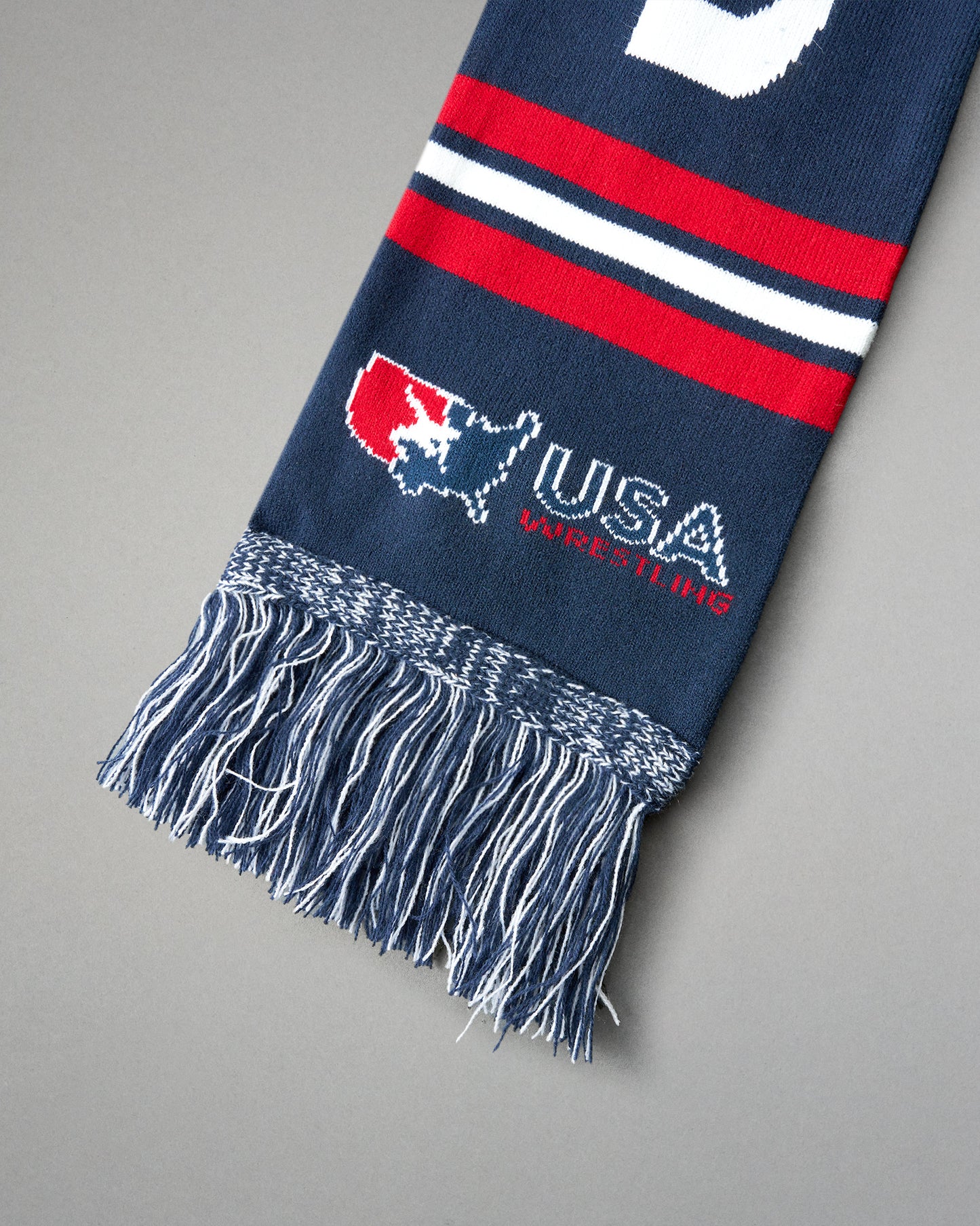 Navy blue scarf with red and white stripes and USA Wrestling logo on a gray background