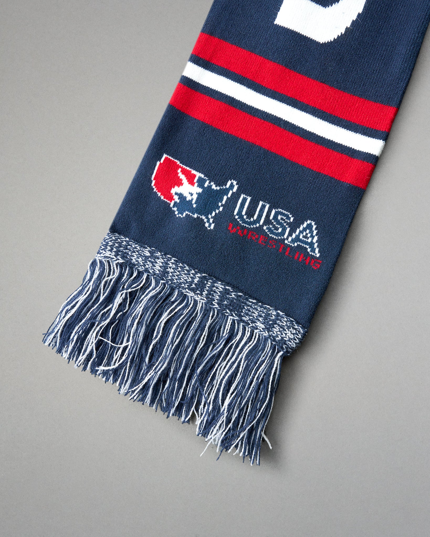Navy blue scarf with red and white stripes and USA Wrestling logo on a gray background