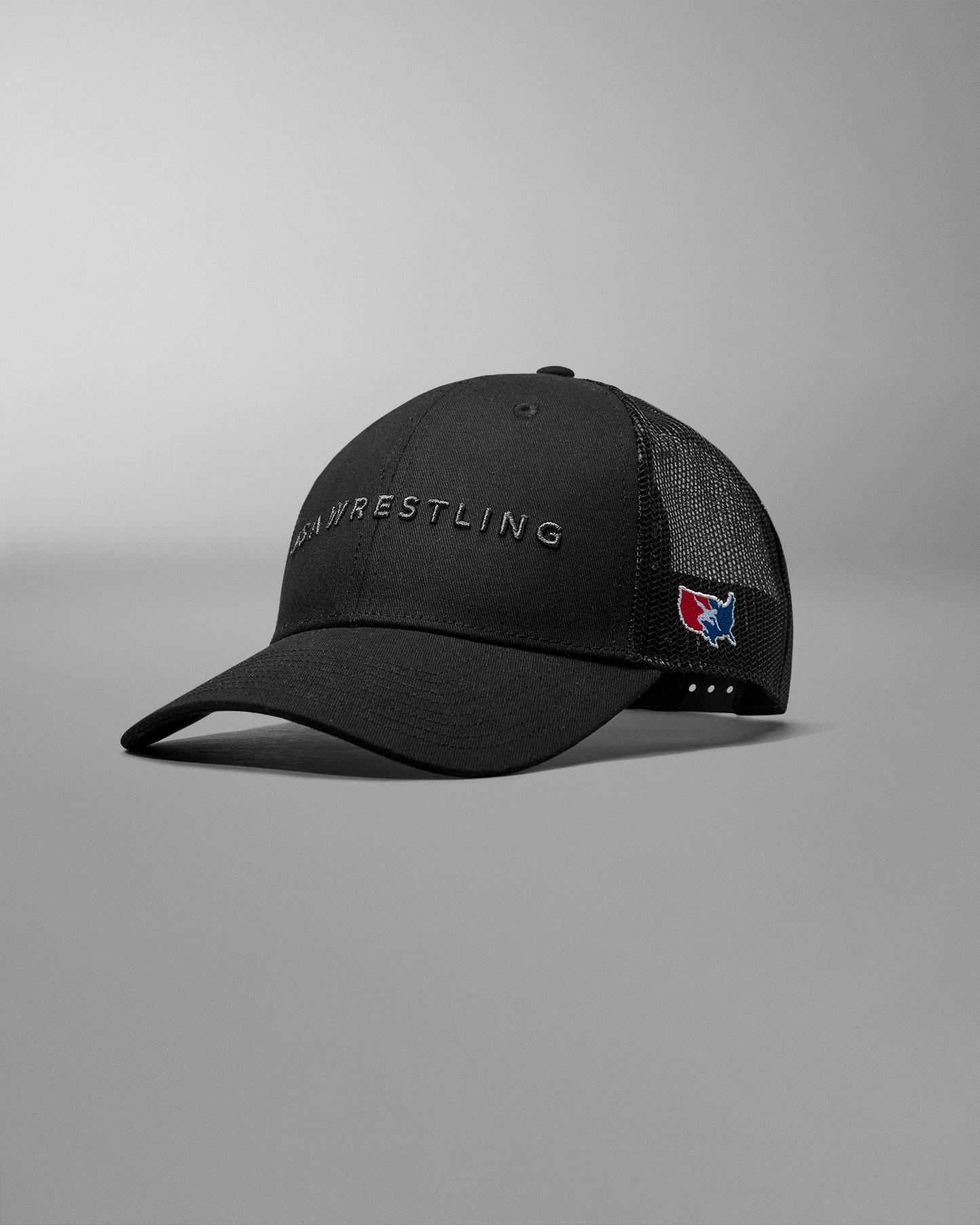 Black wrestling cap with a logo on a gray background