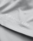 A close-up view of the bottom hem of a light gray athletic shirt. Embossed white text reads “A WAY OF LIFE” with the RUDIS hex logo replacing the letter “O” in “OF.” The stitching and fabric texture are crisp and clearly visible.







