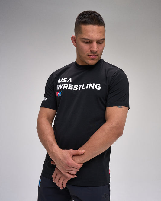Man wearing a black USA Wrestling shirt on a gray background