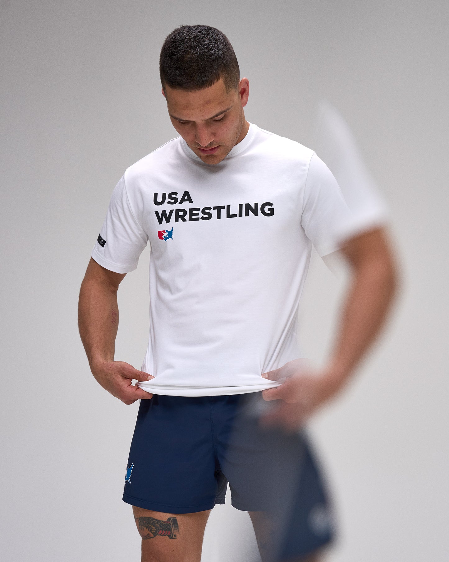 Person wearing a white 'USA Wrestling' t-shirt on a plain background
