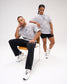 Male and female models wearing the USA Wrestling Map Classic Cotton T-Shirt in light gray tree camo with a USA map and wrestling graphic on the chest, paired with black athletic bottoms.
