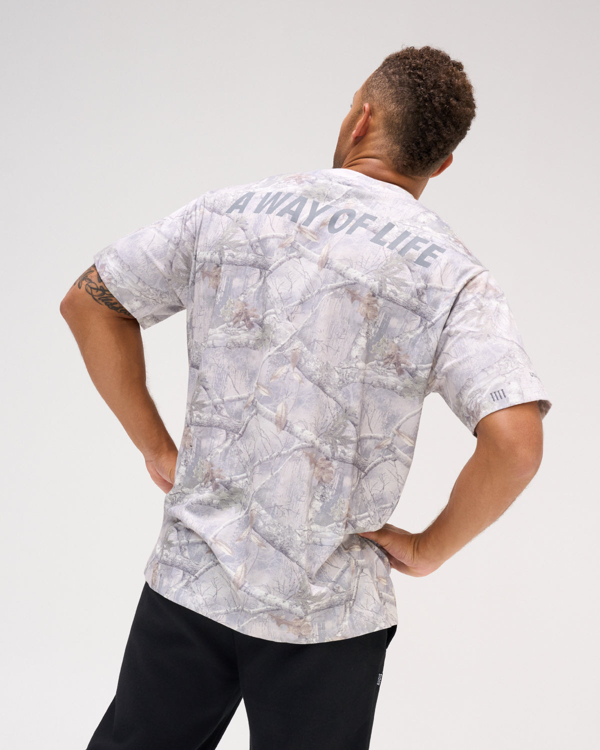 Back view of male model wearing the USA Wrestling Map Classic Cotton T-Shirt in tree camo, featuring gray A WAY OF LIFE lettering across the upper back.