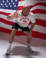 Man in a 'United States Wrestling' t-shirt posing in front of an American flag