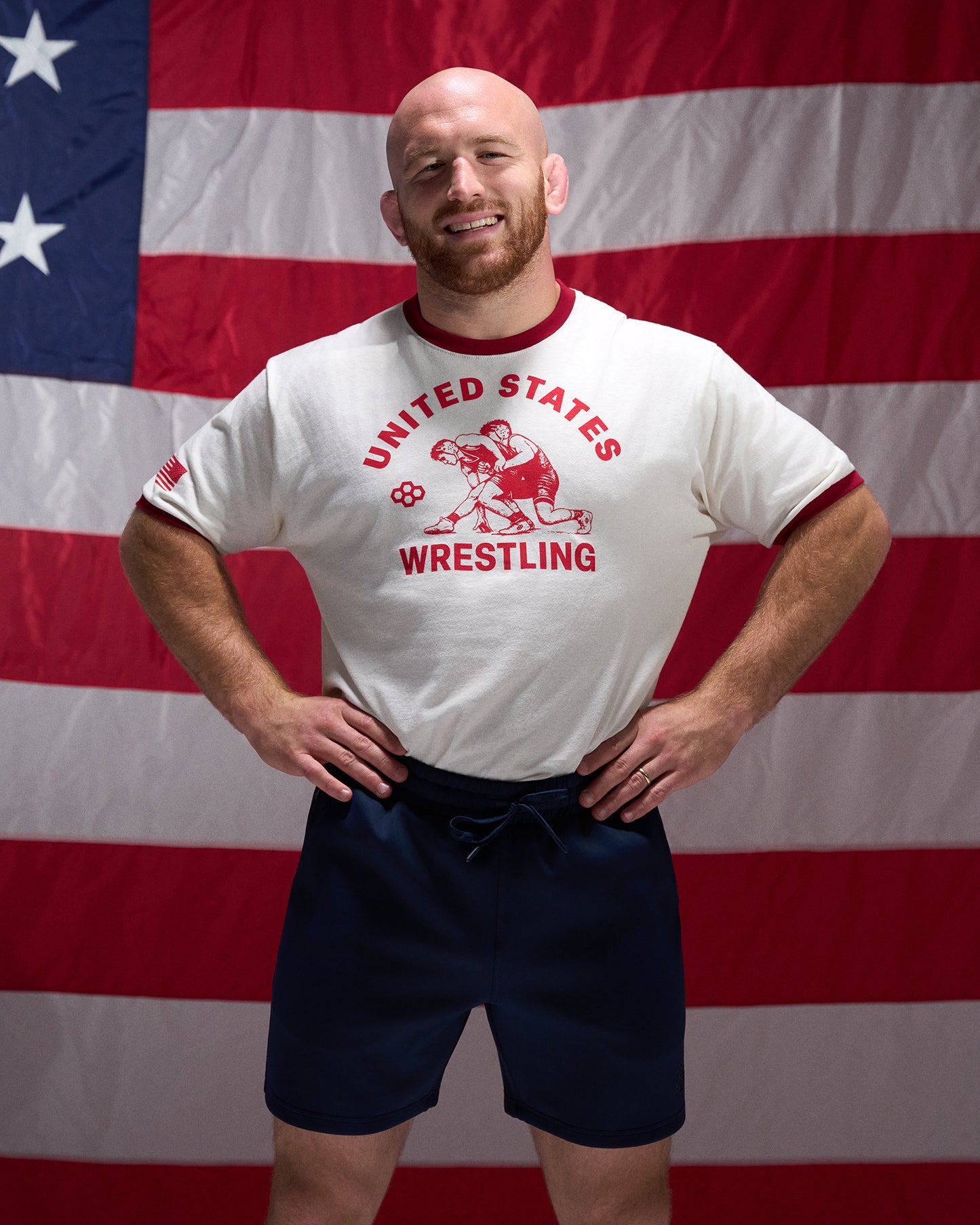 Man wearing a 'United States Wrestling' t-shirt in front of an American flag