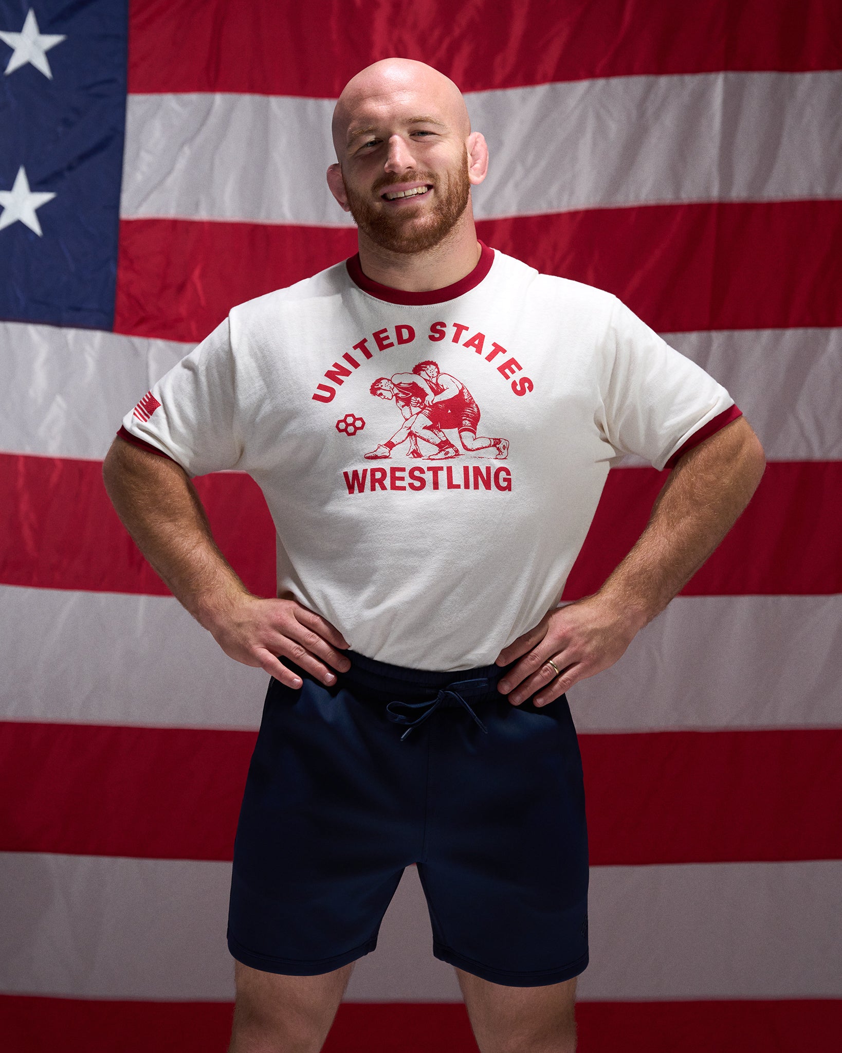 Man wearing a 'United States Wrestling' t-shirt in front of an American flag