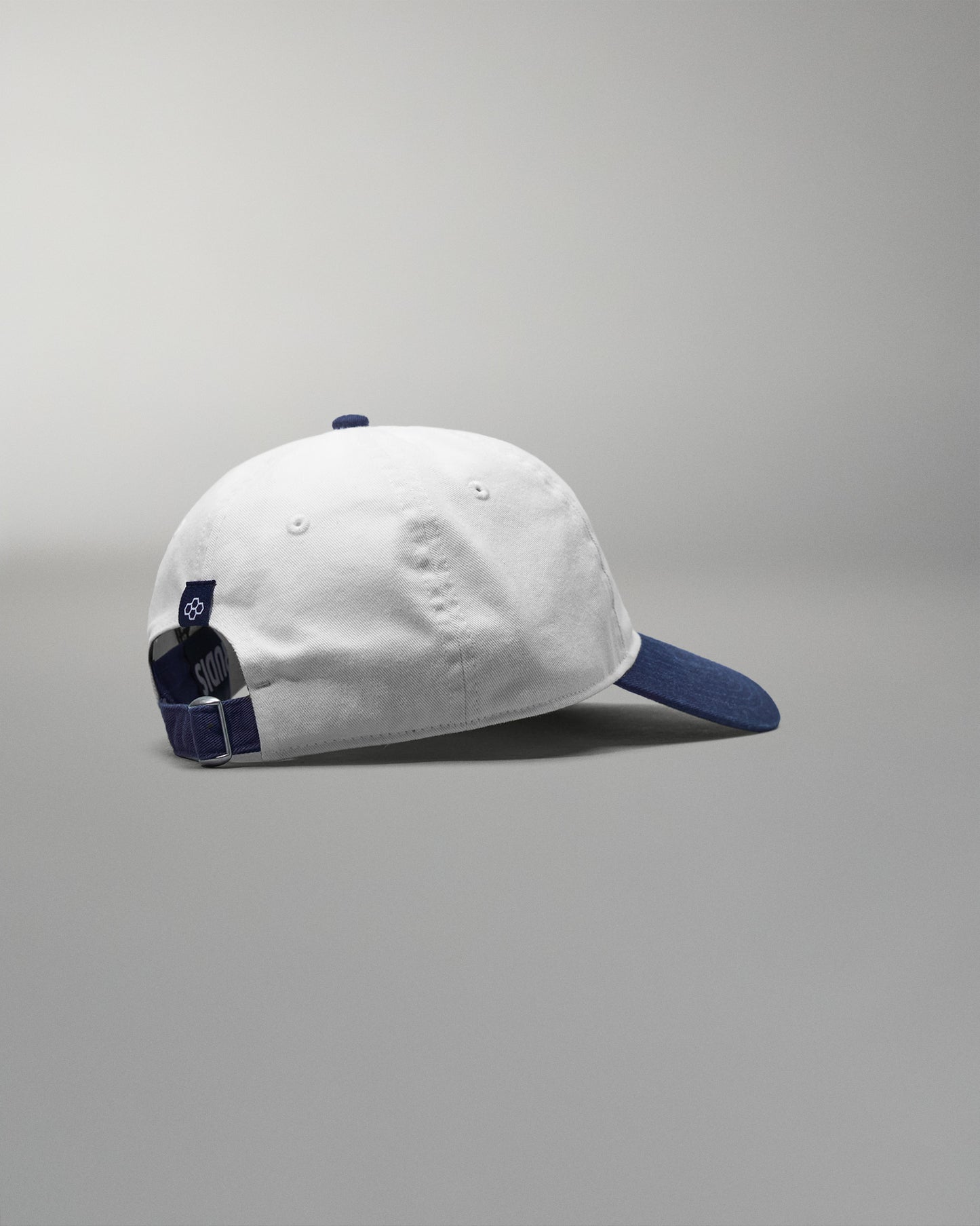 White cap with blue accents on a gray background