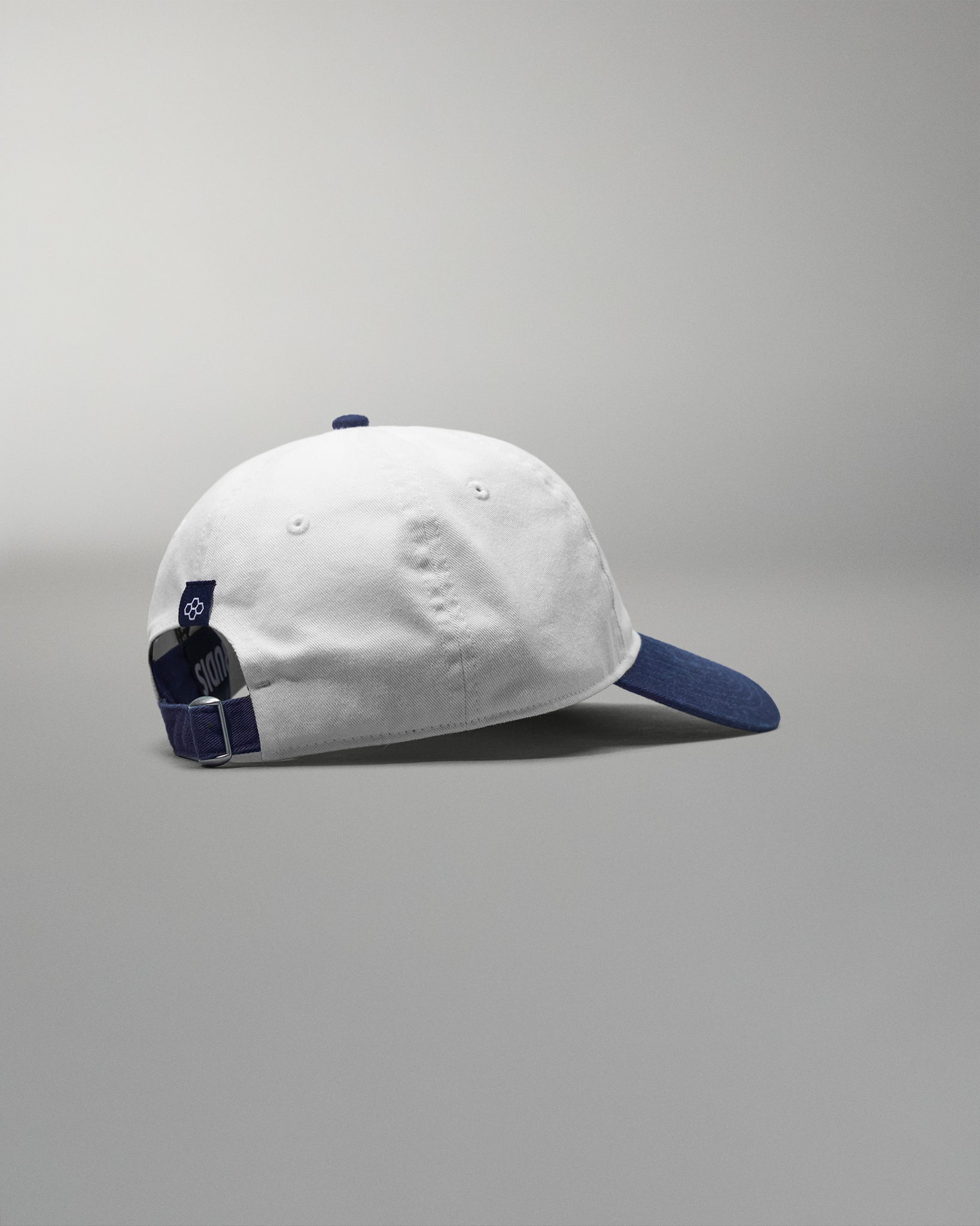White cap with blue accents on a gray background