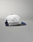 White cap with blue accents on a gray background