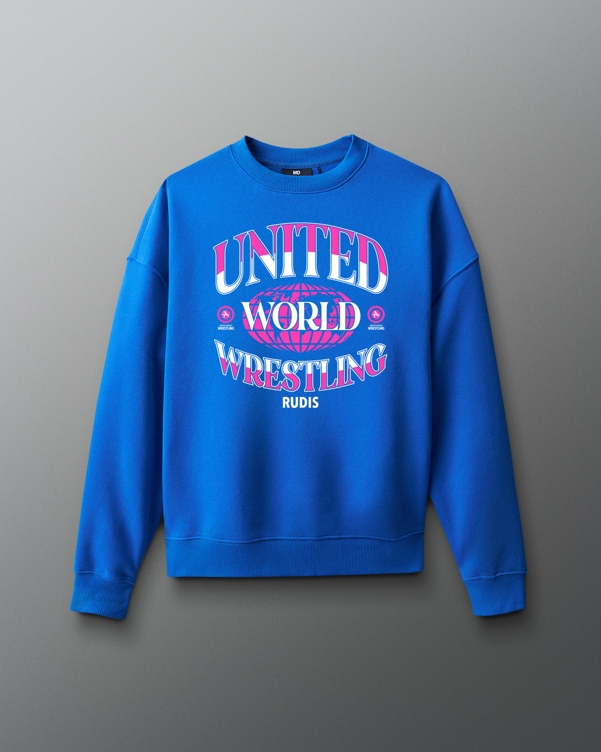 Royal blue RUDIS UWW Globe Relaxed Comfort Fleece Crewneck shown from the front, featuring a bold pink-and-white “UNITED WORLD WRESTLING” globe graphic across the chest with RUDIS branding below.
