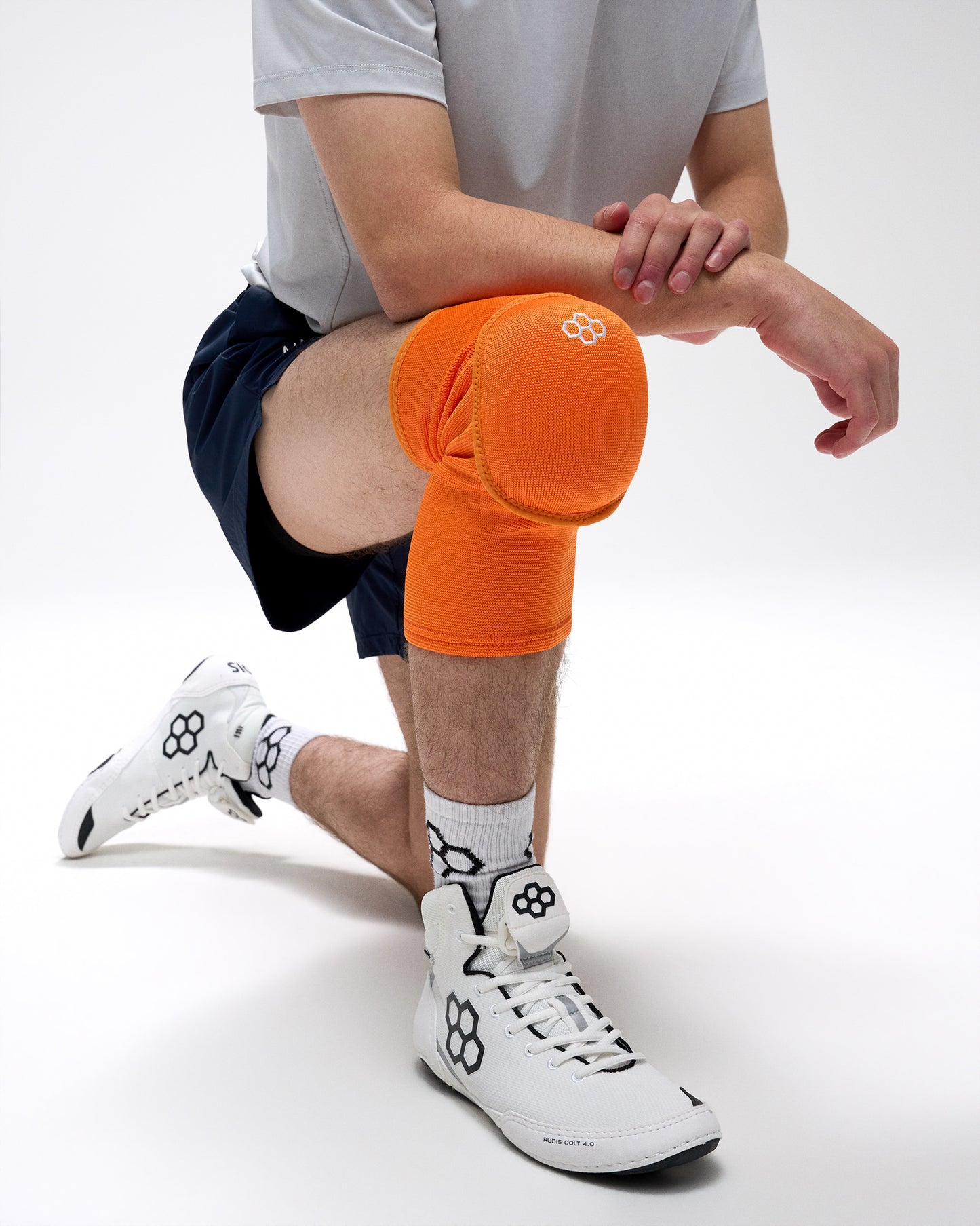 Person wearing an orange knee brace on a white background