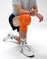 Person wearing an orange knee brace on a white background