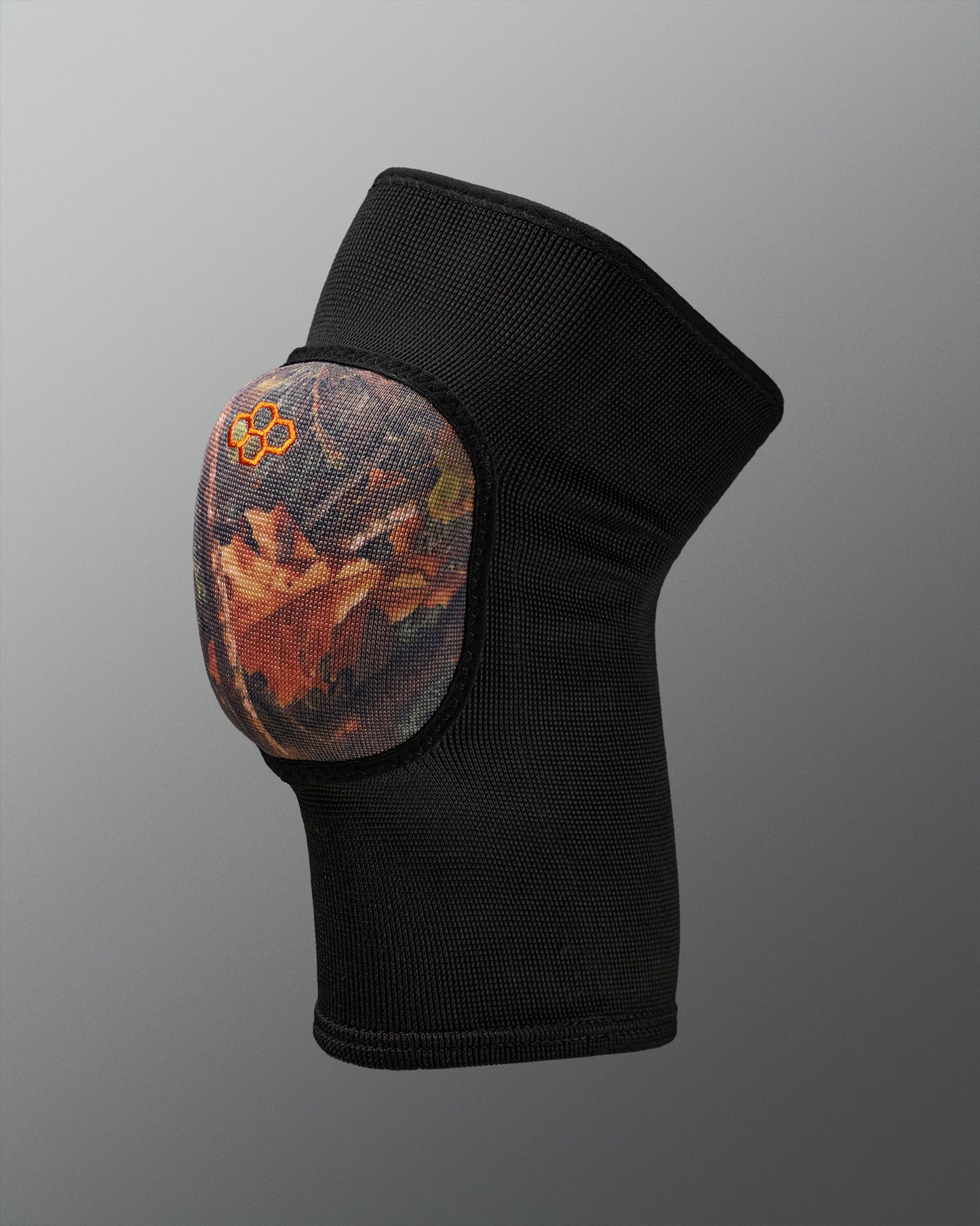 Black knee pad with a camo design on a gray background
